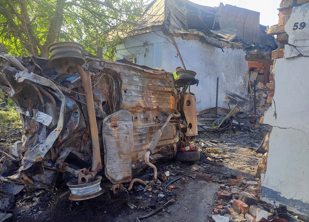 A destroyed car at a site where a house was heavily damaged by a Russian drone strike (Reuters)