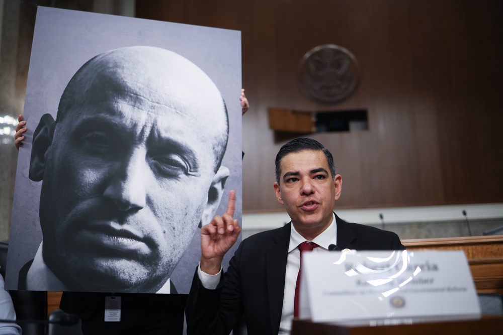 Rep. Robert Garcia (D-CA) speaks while referencing a photo of Deputy White House Chief of Staff Stephen Miller during a public forum on violent use of force by Department of Homeland Security (DHS) agents (Getty)