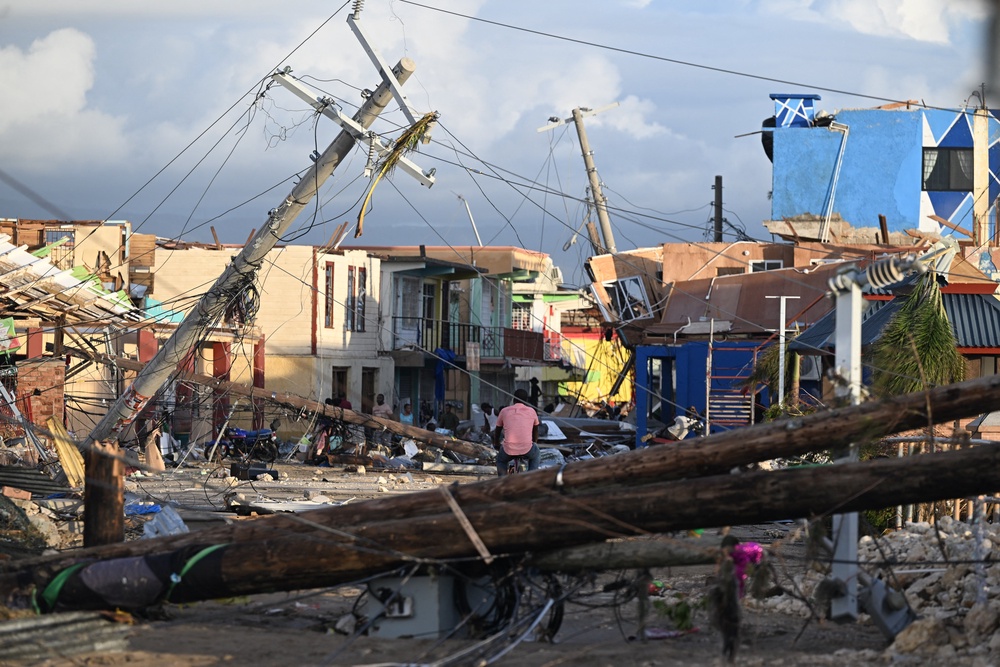 A man bikes through the destroyed neighborhood of North Street following the passage of Hurricane Melissa in Black River, Jamaica, in October 2025. Earlier forecasts helped better prepare people on the ground for the dangerous storm (AFP via Getty Images)