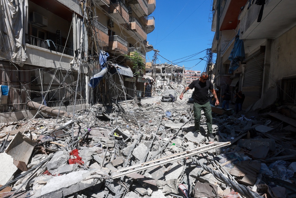 A man walks on rubble at the site an Israeli strike in Tyre, Lebanon (Reuters)