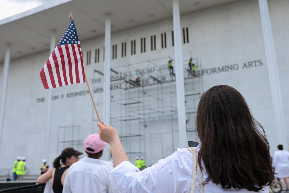 A crowd gathered outside the venue cheering on construction workers and chanting ‘take it off’ before the crew left the site during an afternoon downpour (Reuters)