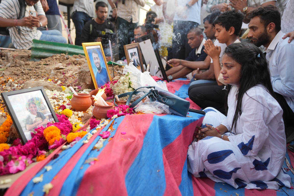 Family members of an Air India crash victims pay tribute at the crash site on the first anniversary of the tragedy, in Ahmedabad, India, Friday (AP)