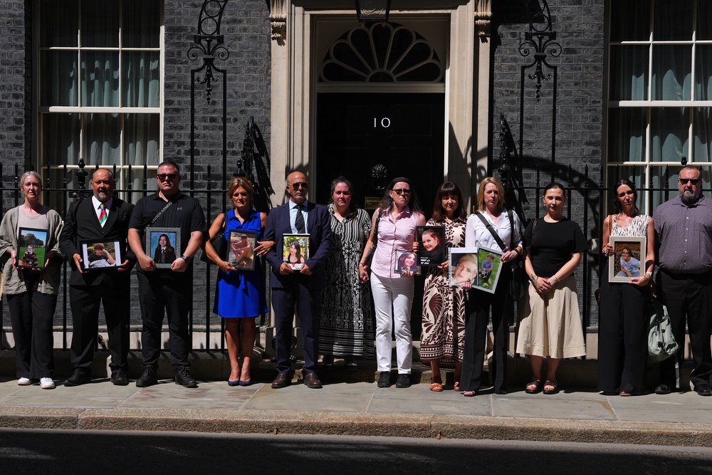 LONDOBereaved parents pose with images of their children outside Downing Street on May 26, 2026 in London, England (Getty)