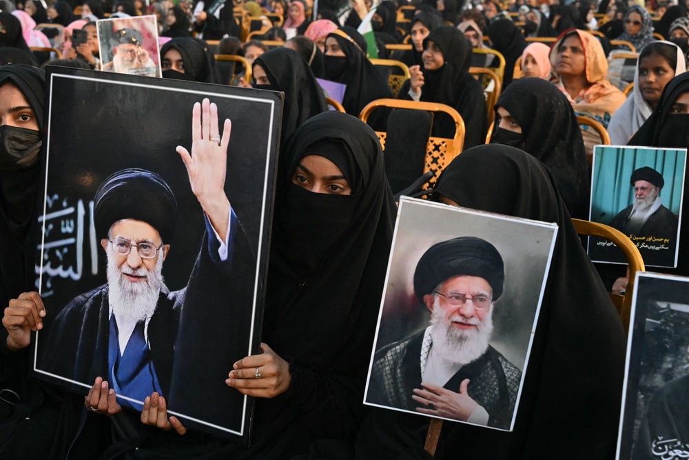 Activists carry portraits of Iran's slain supreme leader Ayatollah Ali Khamenei, as they pay tribute at Minar-e-Pakistan in Lahore (AFP/Getty)