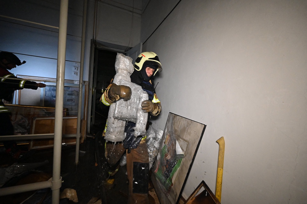 A firefighter walks past damaged paintings at the damaged Kharkiv Art Museum following a drone strike in Kharkiv (AFP/Getty)