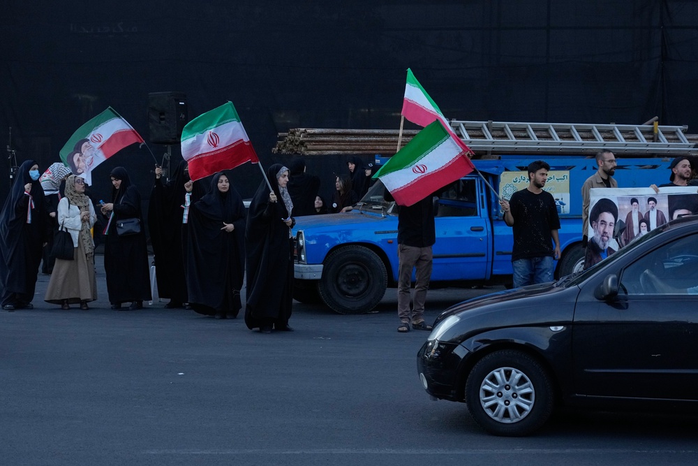 Demonstrators wave Iranian flags in a small group gathering at the Islamic Revolution square in Tehran, Iran, Sunday, June 14, 2026 (AP)