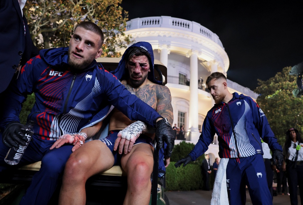 Ilia Topuria (centre) is comforted by his brother Aleksandre (left), who is also his coach (Reuters)