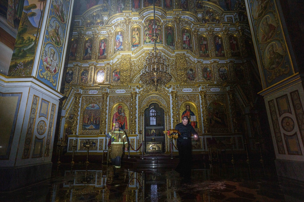 A priest carries church inventory out of the burning Dormition Cathedral of the Kyiv-Pechersk Lavra during a Russian strike on Kyiv (AP)