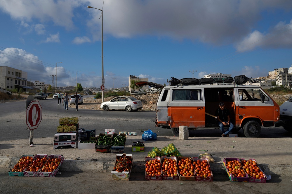 A Palestinian street vendor waits for customers at the eastern outskirts of the West Bank city of Nablus (AP)