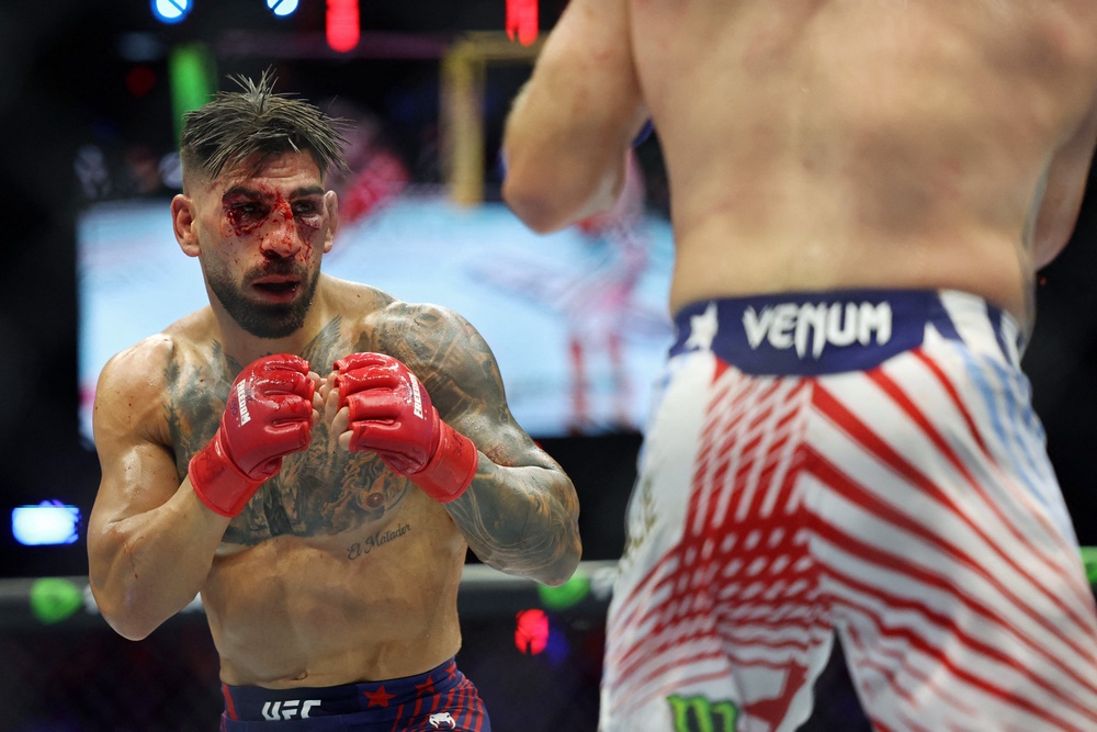 Ilia Topuria (red gloves) was battered early by Justin Gaethje during UFC Freedom 250 on the White House South Lawn and could barely see through the blood and swelling before the fight was called (Reuters)