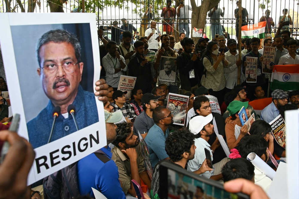 Cockroach Janata Party (CJP) activists a hold placard featuring India's Education Minister Dharmendra Pradhan during a protest over alleged irregularities in the country's major examinations in Hyderabad on June 14, 2026 (AFP/Getty)
