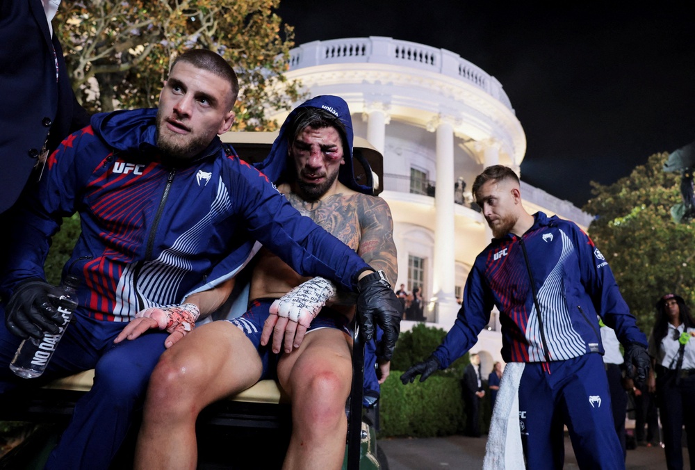 Ilia Topuria (centre) comforted by his brother Aleksandre, who is also his coach (Reuters)