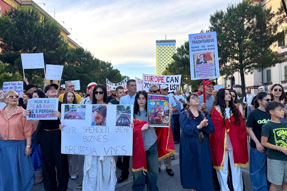 Protestors march down Dëshmorët e Kombit Boulevard in Tirana (Annabel Grossman/The Independent)