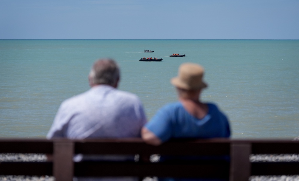 A couple watch two small boats hug the coastline near Ault in France as people thought to be migrants attempt to cross the Channel (Gareth Fuller/PA) (PA Wire)