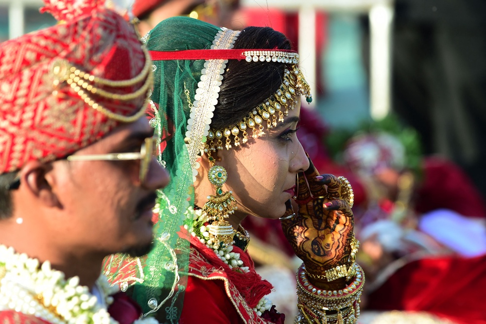 A newlywed couple looks on during the marriage of 20 Hindu couples in Ahmedabad on 11  February 2023 (AFP/Getty)