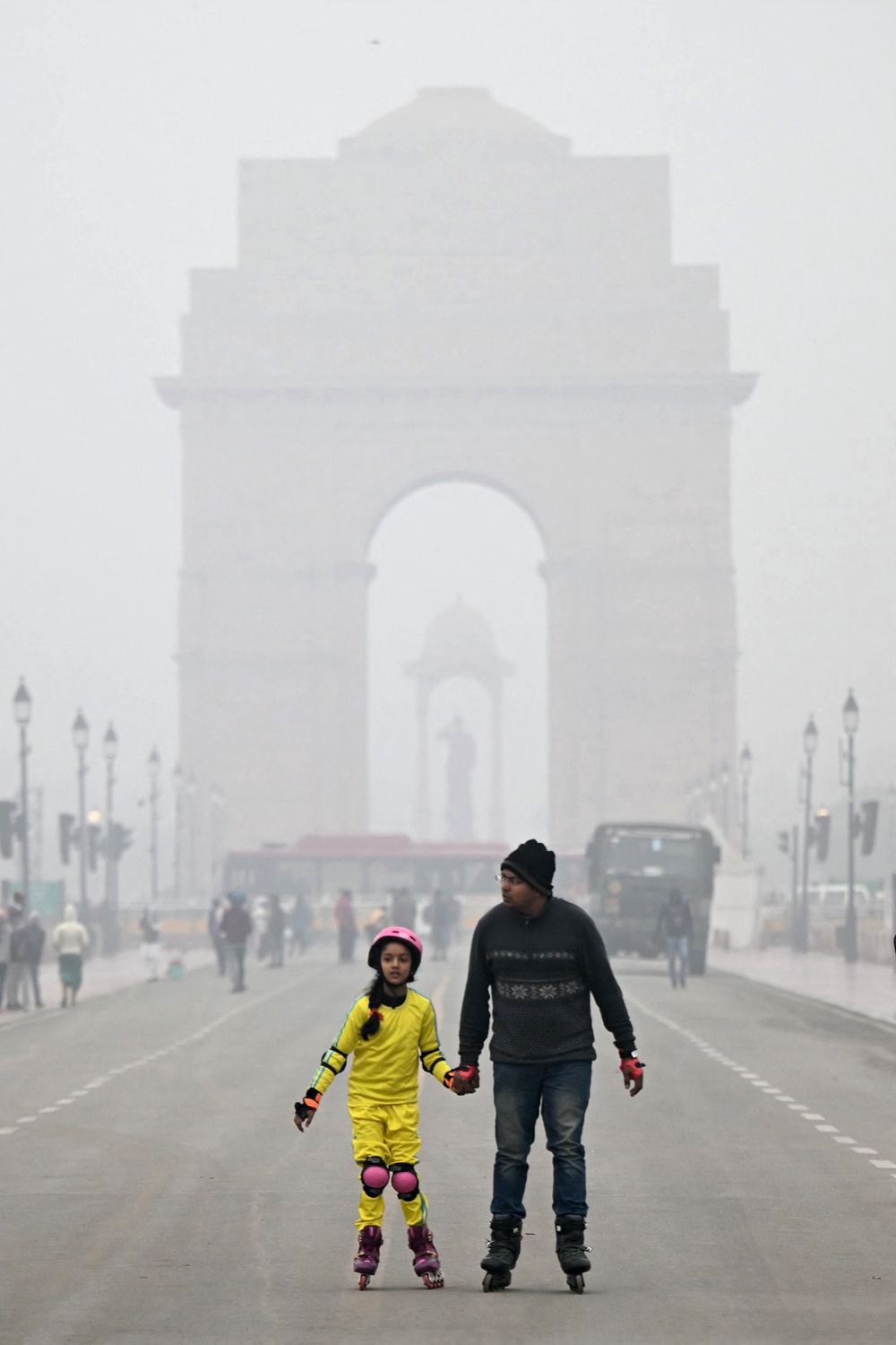People skate in front of India Gate on a cold foggy winter morning in New Delhi on 3 January 2024 (AFP/Getty)