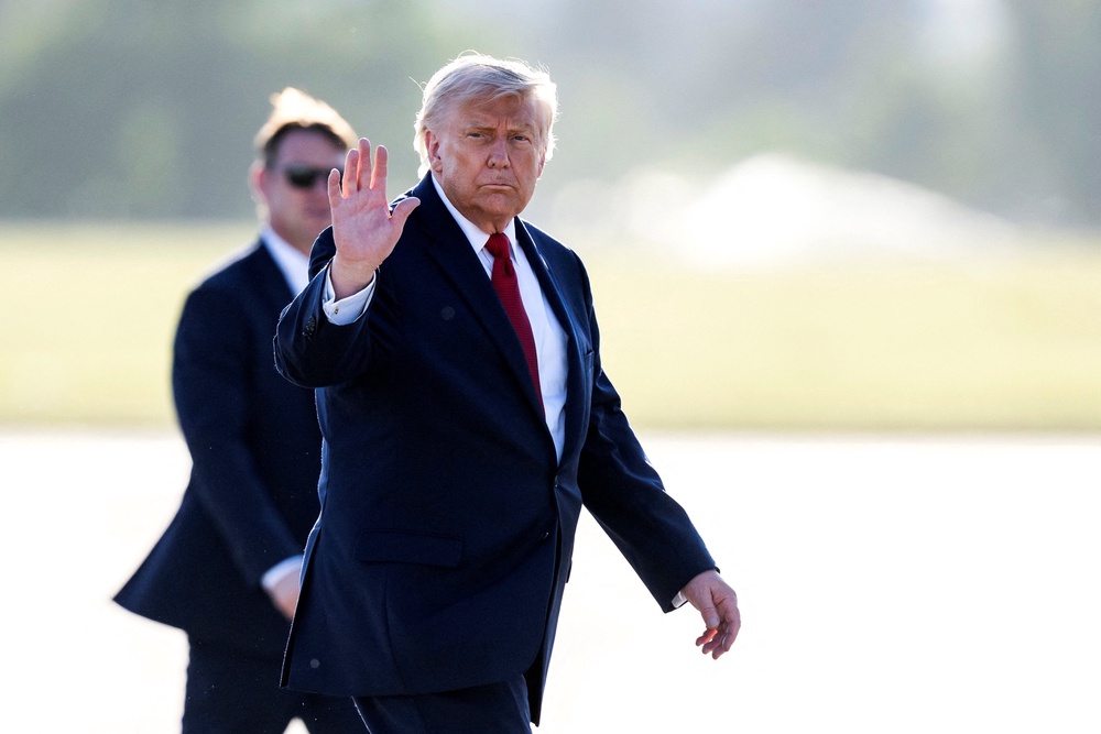 Donald Trump gestures as he walks to board Air Force One at Geneva Airport following the G7 summit (Reuters)