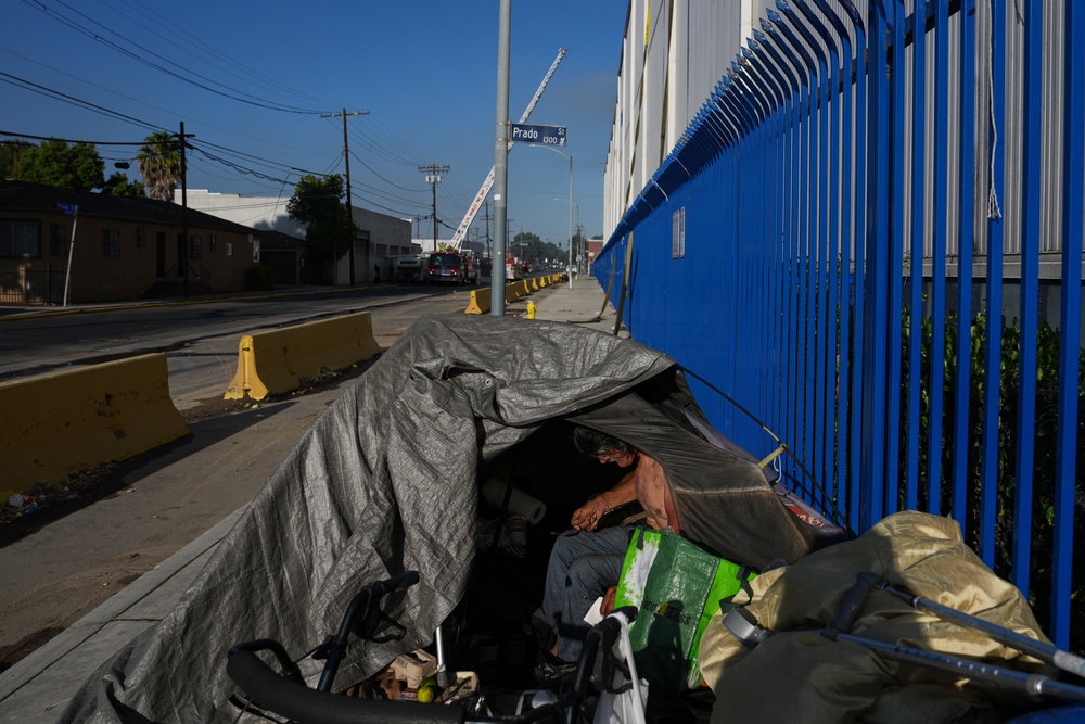 A homeless person camps near the site of a warehouse fire in the Boyle Heights section of Los Angeles (AP)