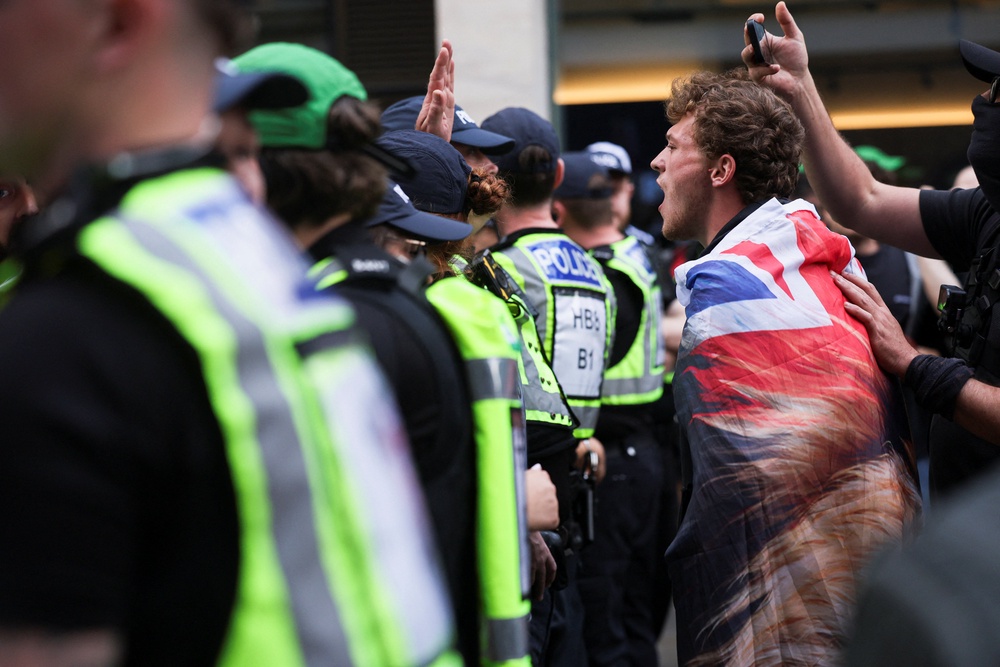 A counterprotester shouts over a line of police officers during the ‘All Out Against Tommy Robinson’ protest (Reuters)