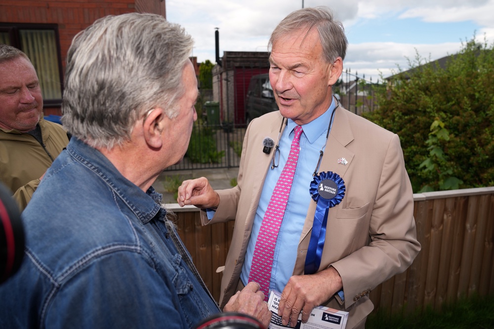 Britain's leader of Restore Britain Rupert Lowe speaks to a member of the public (AP)