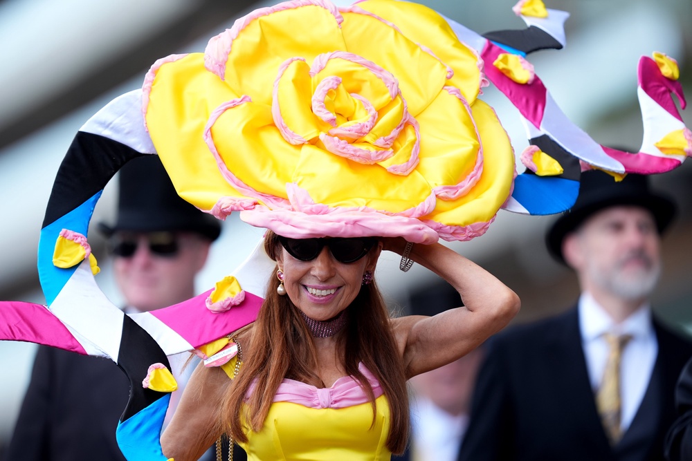 A large hat featuring a yellow flower was worn by one racegoer, whose dress was also a bright yellow (Mike Egerton/PA) (PA Wire)