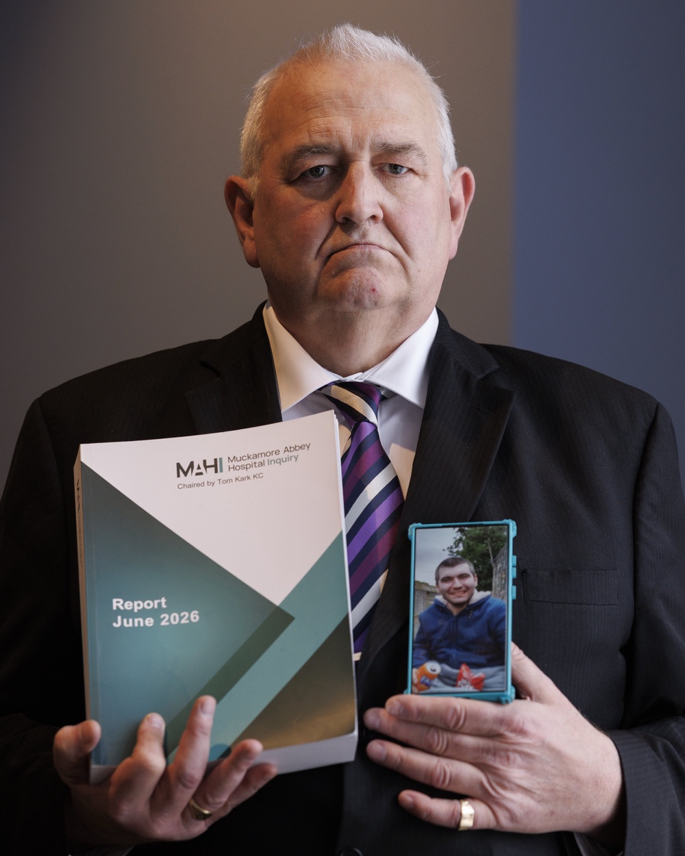 Glynn Brown, father of Aaron Brown, holding a photograph of Aaron and a copy of the Muckamore Abbey Hospital Inquiry final report at the Ramada Hotel, Talbot Street, Belfast, as he reacted to its publication (Liam McBurney/PA). (PA Wire)