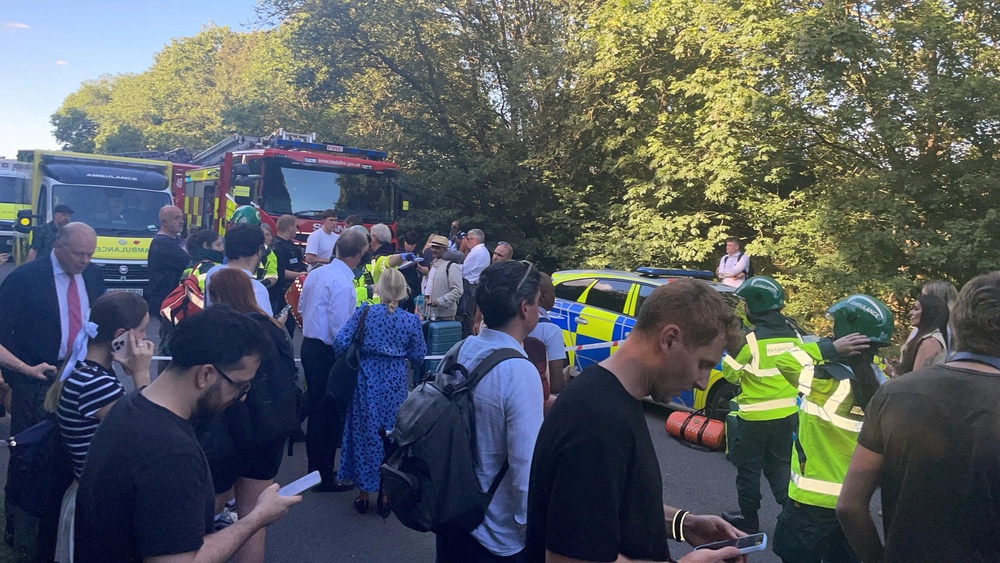 People and emergency service workers gather near the scene (Reuters)