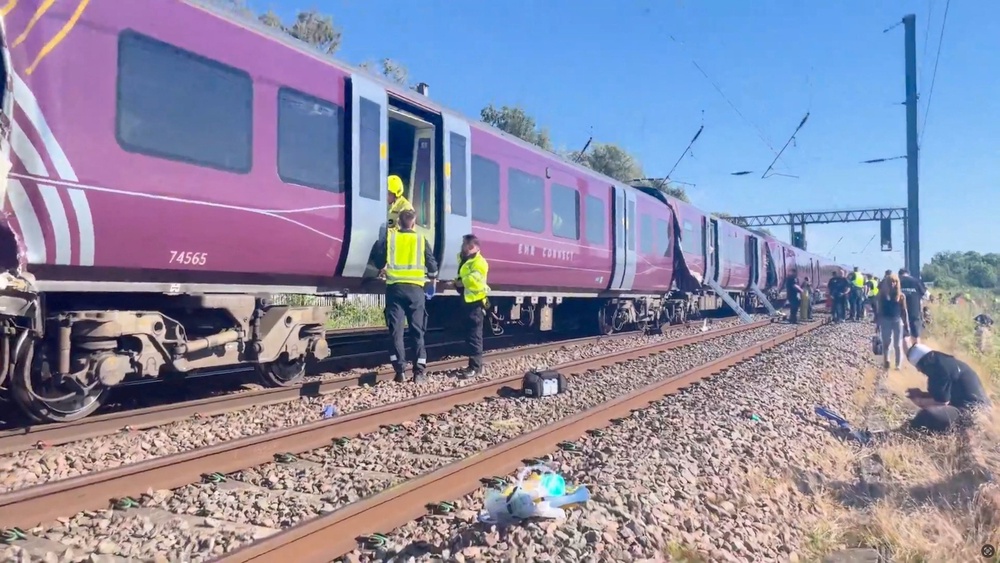 Emergency service workers gather at the scene of a collision involving two trains near Bedford (Reuters)