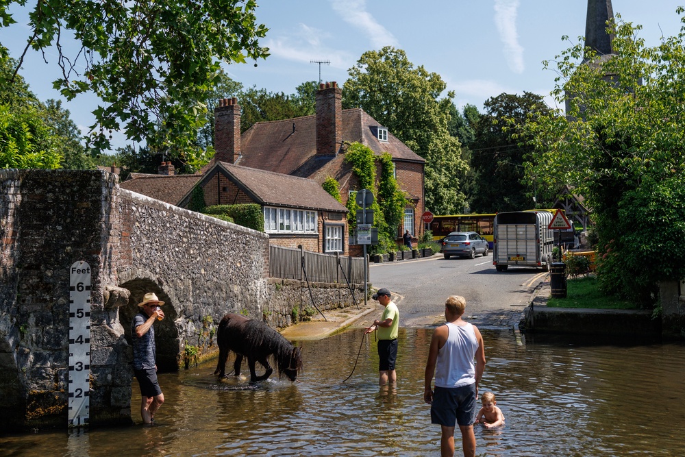 Families cool off in the River Darent in Eynsford on Friday (Getty)