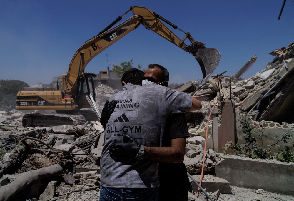 Rescuers embrace as they work at the site of an Israeli air strike in Barish, Tyre district, Lebanon, June 20, 2026. (Reuters)