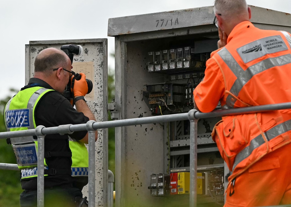 A Crime Scene Manager from the British Transport Police photographs the inside of an trackside Location Case (LOC), commonly used to house signalling equipment (AFP/Getty)