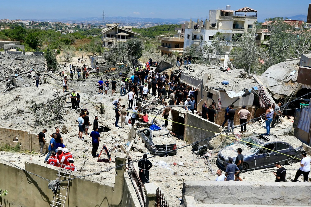 Civilians and first responders gather at the site of an Israeli airstrike that targeted the southern Lebanese village of Qennarit on Saturday (AFP/Getty)