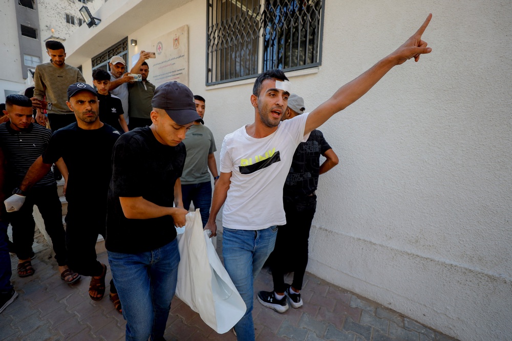 Palestinians carry a shrouded body following an Israeli strike on the Al-Maghrebi area in Gaza City (AFP/Getty)