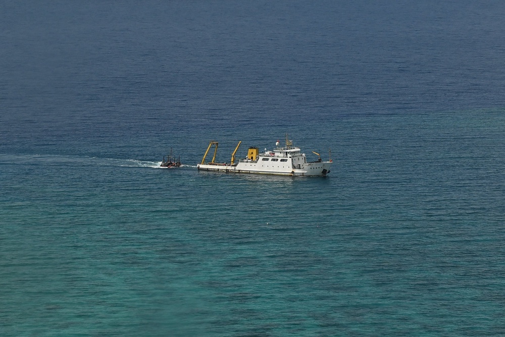 A ship identified by the Philippine Coast Guard as a Chinese research vessel is seen towing a floating structure at the mouth of Scarborough Shoal in the disputed South China Sea (AFP/Getty)