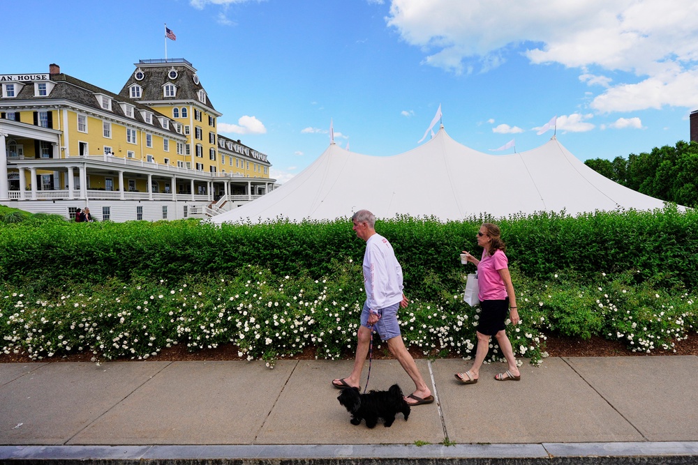 A couple walks by the Ocean House hotel where a temporary event tent prompted speculation of the possibility of Taylor Swift's impending wedding (AP)
