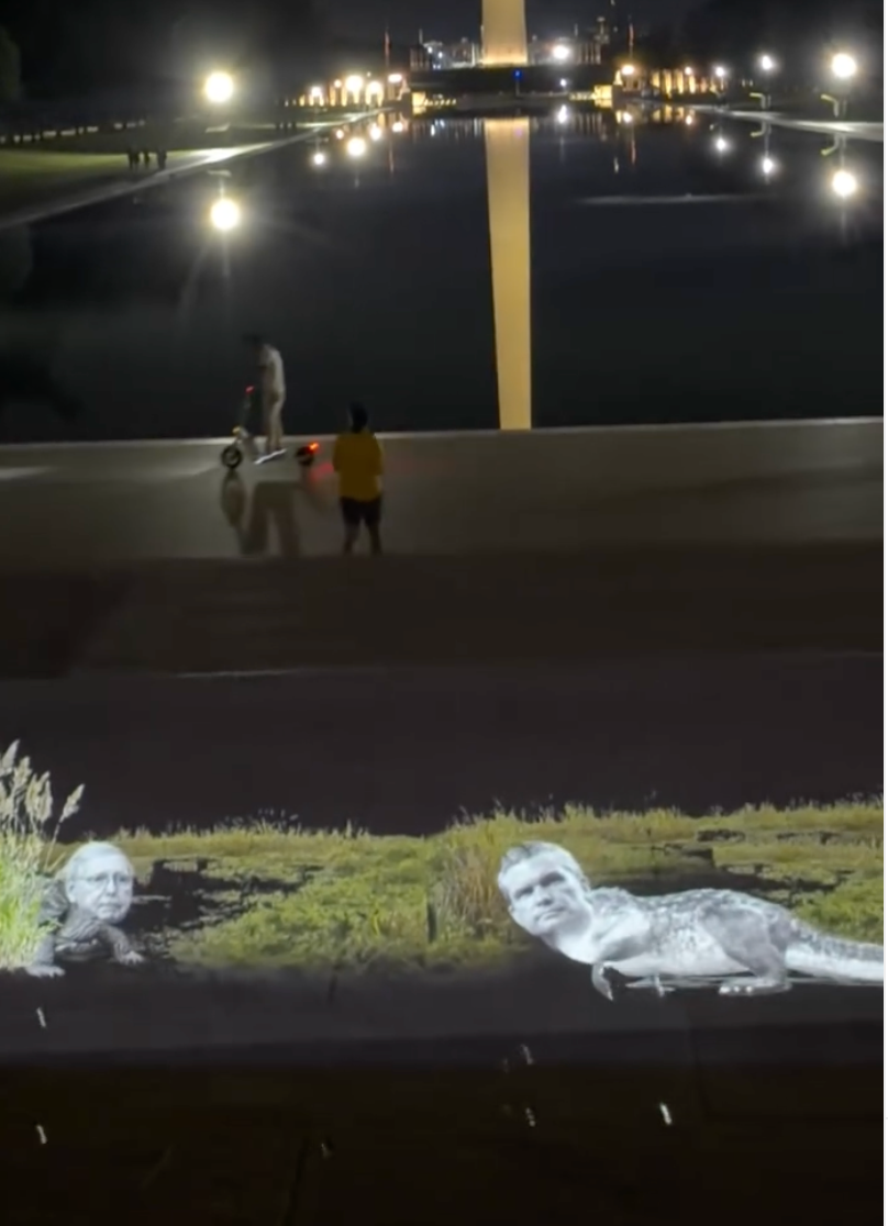 Projections across Washington DC from prankster group VJayBombs portrayed Senator Mitch McConnell and Defense Secretary Pete Hegseth as swamp creatures near the Lincoln Memorial Reflecting Pool (VJayBombs)