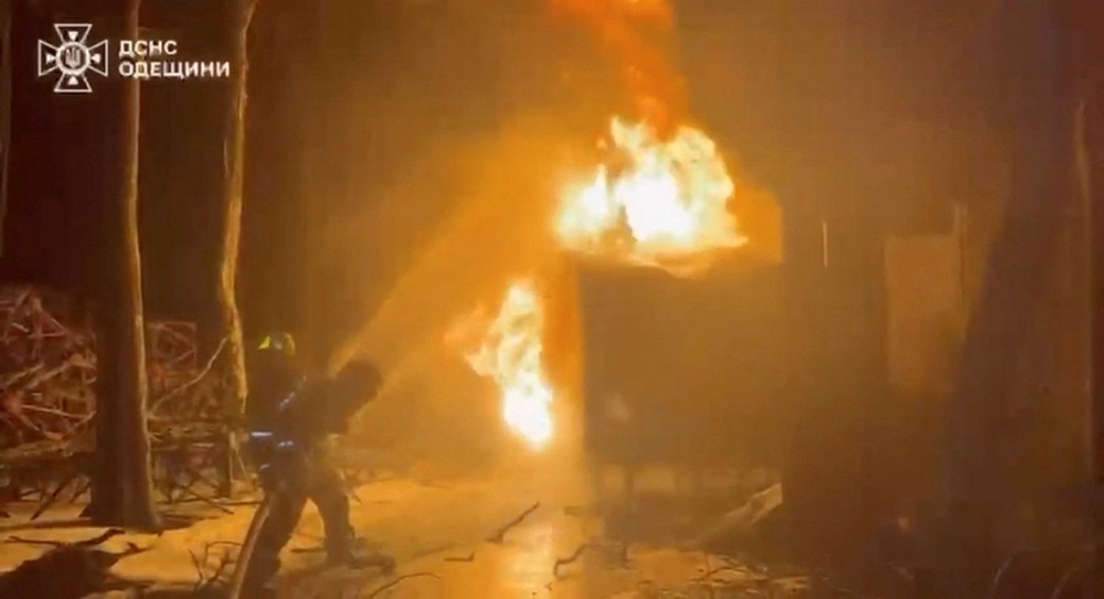 A firefighter attempts to put out a fire after a Russian strike, amid Russia's attack on Ukraine (Reuters)