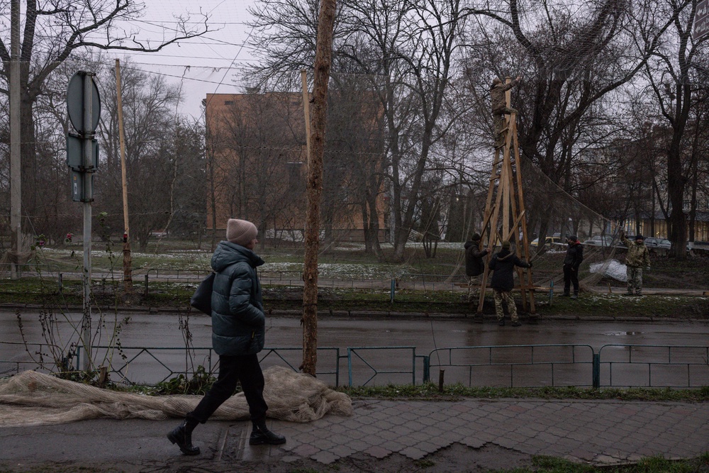 Members of the Ukranian Armed Forces install anti-drone nets in the city centre of Izyum on 10 December 2025 as people expect Russia to intensify its attacks as it advances in the Donbas region. (Getty)
