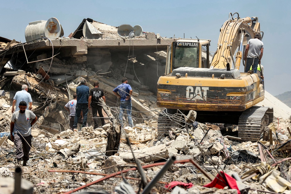 An excavator clears rubble from the site of a collapsed building, following Israeli bombardment in Nabatieh in southern Lebanon on June 21 (AFP/Getty)