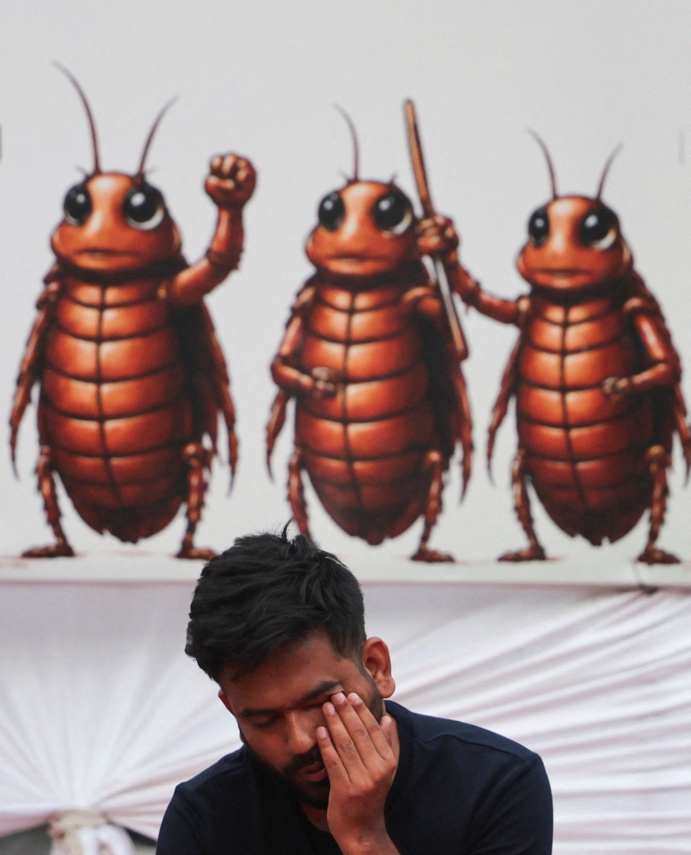 Abhijeet Dipke, head of the CJP, wipes his eyes as he gets up after sleeping the night on a stage during the sit-in protest (Reuters)