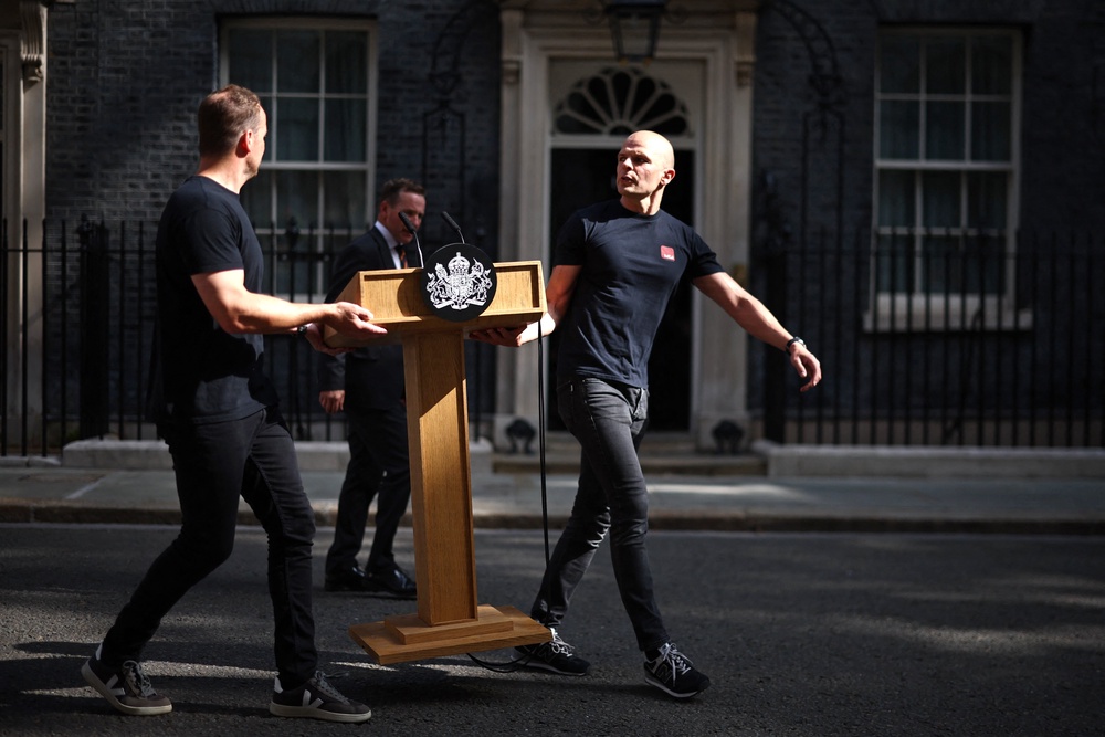Members of staff bring the lectern outside 10 Downing Street (AFP/Getty)