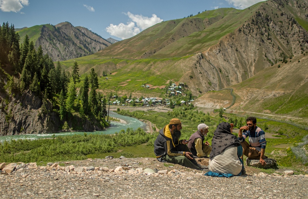 Local people sit on the side of the road with the view of the river in the Gurez valley in Bandipora, India-administered Jammu and Kashmir, near India-Pakistan border on 5 June 2025 (AFP/Getty)