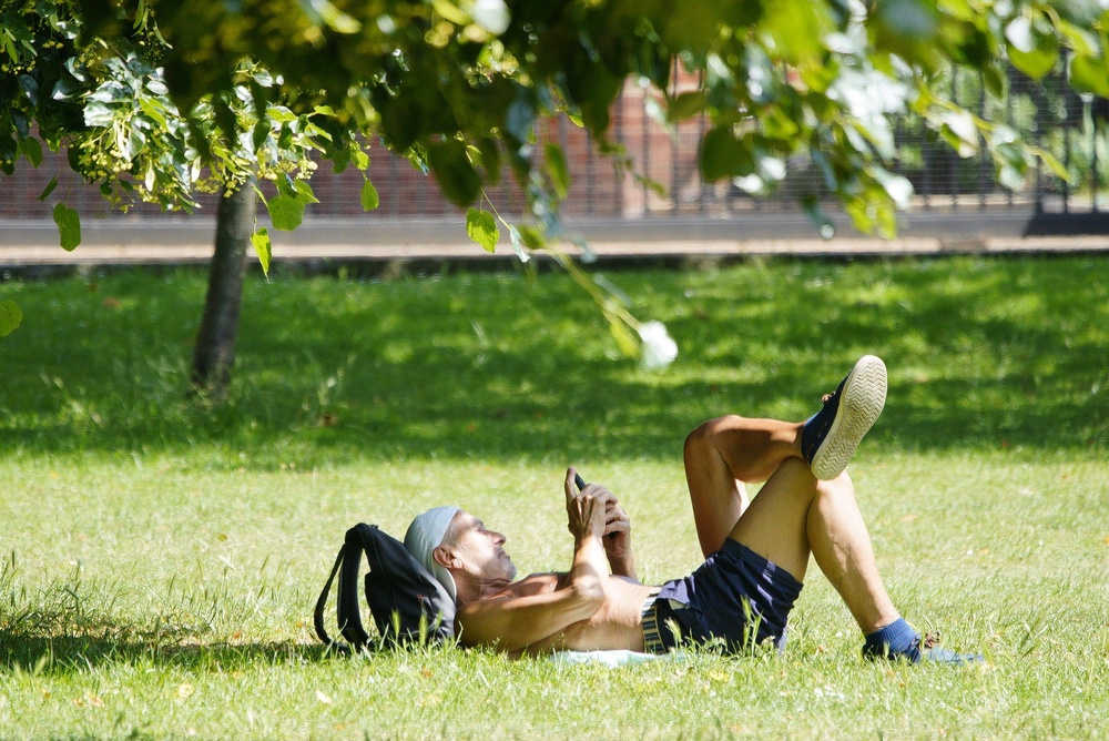 A person sunbathes in Richmond Green, south-west London as the UK is set to bake in record-breaking temperatures which could soar to more than 38C (Ben Birchall/PA) (PA Wire)