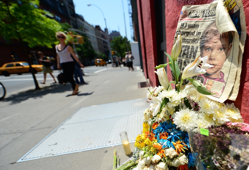 People walk past a street shrine to Etan Patz in front of the building where suspect Pedro Hernandez confessed to have strangled the boy (AFP/Getty)