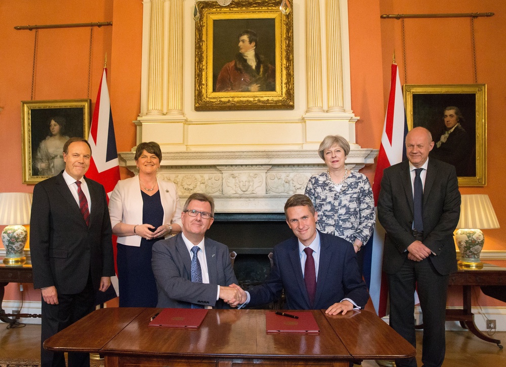 Donaldson (seated left) shakes hands with then Conservative Party Chief Whip Gavin Williamson after the DUP agreed a deal to support the minority Conservative government in 2017 (PA) (PA Archive)