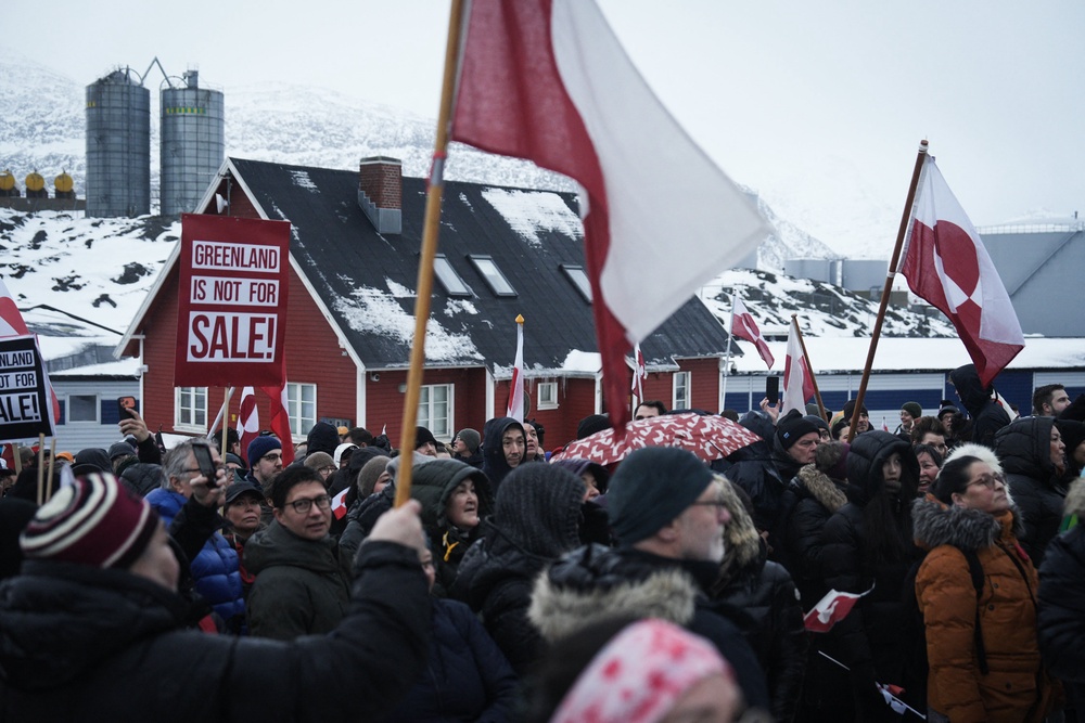 People wave Greenlandic flags as they take part in a demonstration that gathered almost a third of the city population to protest against the US President's plans to take Greenland, on January 17, 2026 in Nuuk, Greenland (AFP via Getty Images)