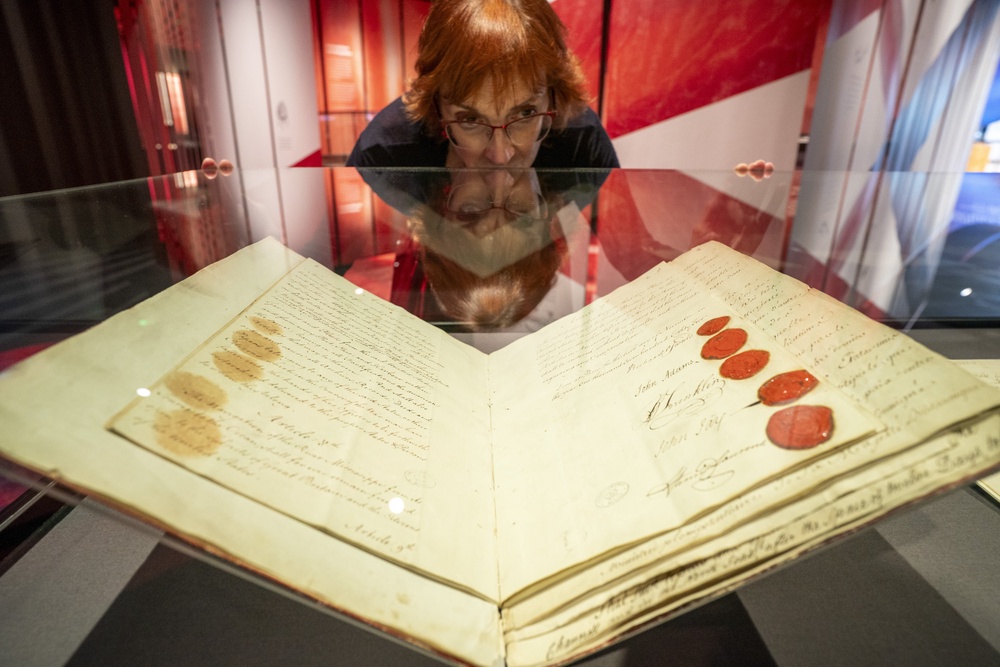 Staff look at provisional articles of the Treaty of Paris, 30 November 1782, including signatures from John Adams and Benjamin Franklin, inside a glass cabinet (Ben Birchall/PA) (PA Wire)