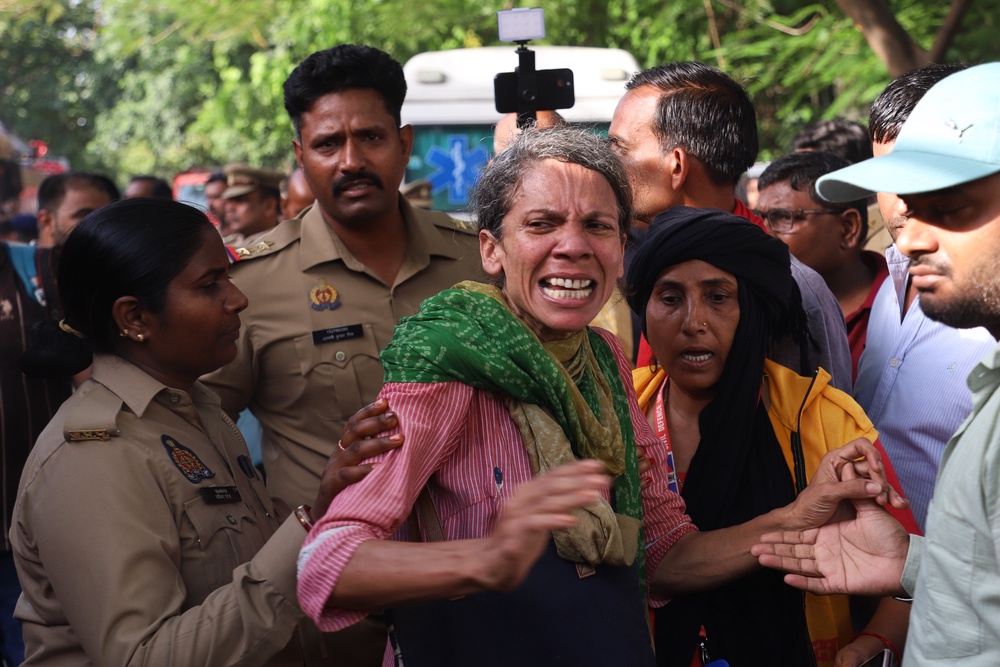 Family members of victims outside the building in Lucknow (AP)