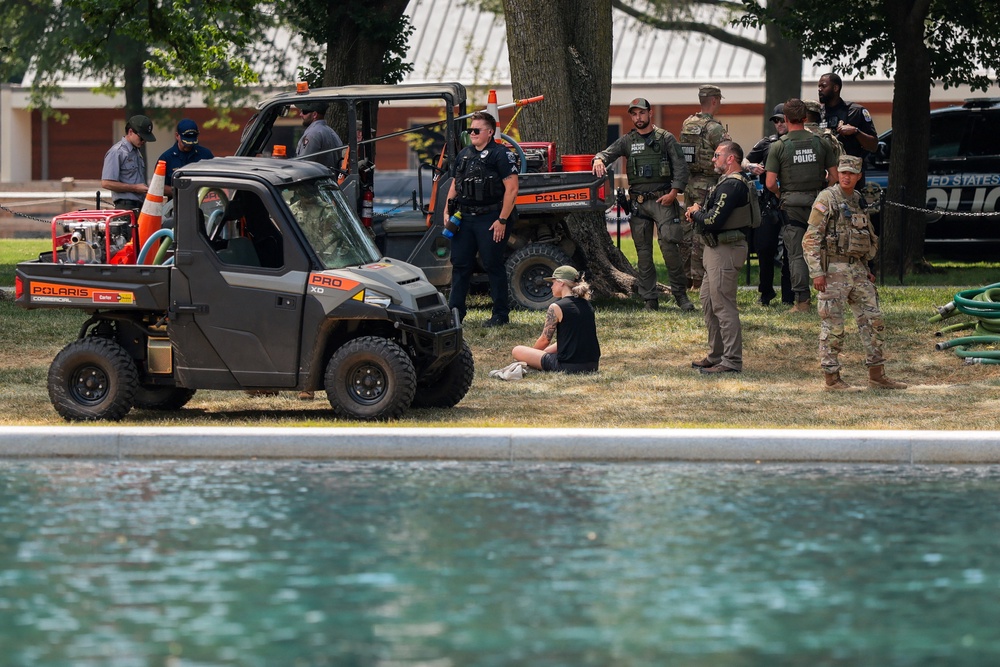 A woman was caught on video being detained by a large number of officers after touching the water (Reuters)