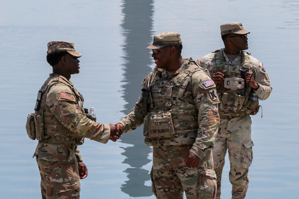 Members of the National Guard shake hands as they patrol the Lincoln Memorial Reflecting Pool (Reuters)